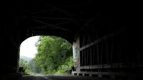 WS Interior of Covered Bridge Looking Onto Foggy Country Road; Dolly Shot Stock Footage 127266979