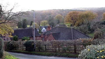WS rooftops in small village on edge of forest Stock Footage 85591969