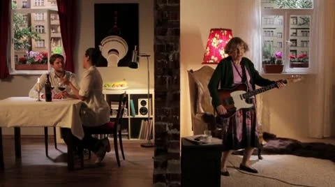 WS of a senior woman playing guitar and irritating her neighbors, split screen Stock Footage