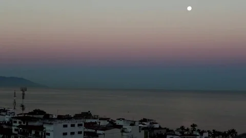 WS sunrise sky, ocean, moon and houses in foregrownd Stock Footage 78008553
