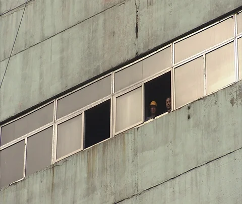 WS Workers looking out from window in old coal burning power plant Stock Footage 86744656