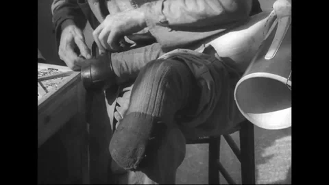WW2 - Wounded man apply shoes on prothesis Stock Footage 108893057