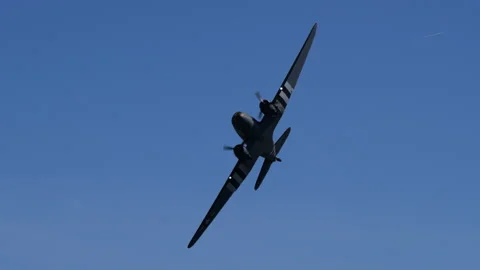 WWII C-47 Skytrain Banking Low With Invasion Stripes In Blue Sky Stock Footage 328393057