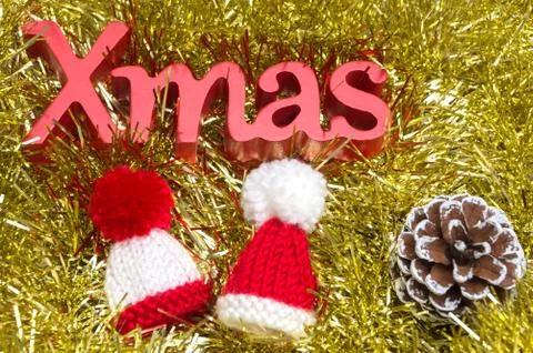 X-mas text and pine cone, fur hat on christmas decoration Stock Photos