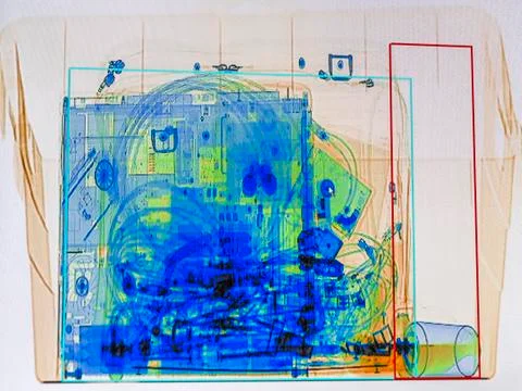 X-ray screenshot of a box with a spray bottle, a bottle of water, a laptop and a Stock Photos