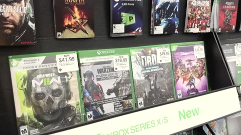 Xbox game selection on shelf establishing shot 4k Stock Footage 332083398