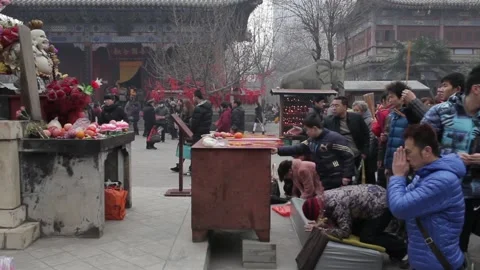XI'AN, CHINA - FEB 14, 2014: Crowded tourists praying for wealth and health in Stock Footage 123716171