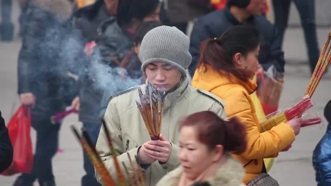 XI'AN, CHINA - FEB 14, 2014: Crowded tourists praying for wealth and health in Vídeo Stock 123716241