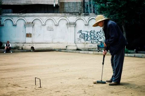 Xi'an / China - JUN 24 2011: elderly man playing croquet in a park with frien Stock Photos