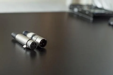 Xlr audio cable on top of a black table. Connections on display. xlr cable co Stock Photos