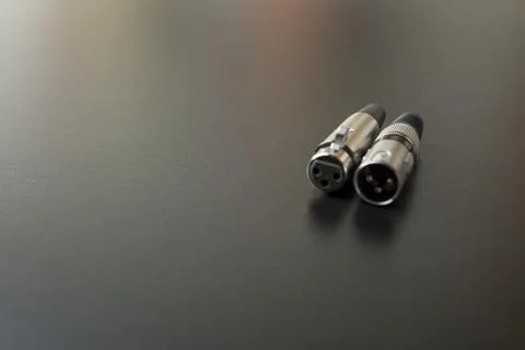 Xlr audio cable on top of a black table. Connections on display. xlr cable co Stock Photos