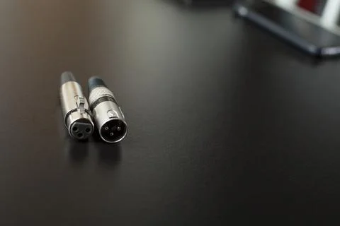 Xlr audio cable on top of a black table. Connections on display. xlr cable co Stock Photos
