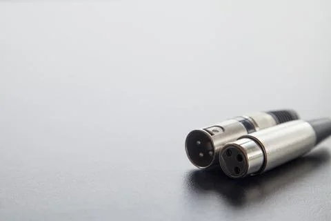 Xlr audio cable on top of a black table. Connections on display. xlr cable co Stock Photos