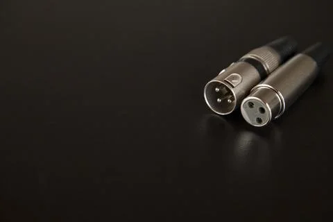 Xlr audio cable on top of a black table. Connections on display. xlr cable co 스톡 사진