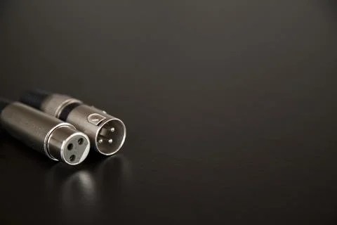 Xlr audio cable on top of a black table. Connections on display. xlr cable co Stock Photos