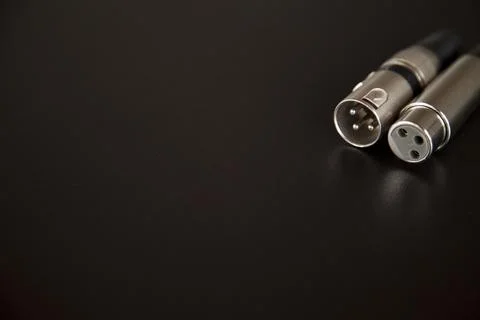 Xlr audio cable on top of a black table. Connections on display. xlr cable co Stock Photos