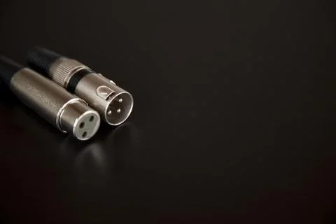 Xlr audio cable on top of a black table. Connections on display. xlr cable co 스톡 사진