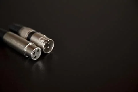 Xlr audio cable on top of a black table. Connections on display. xlr cable co Stock Photos