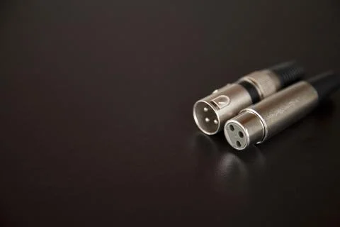 Xlr audio cable on top of a black table. Connections on display. xlr cable co Stock Photos