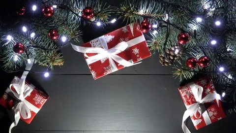 Xmas tree with blurred blinking lights, gifts on black wooden table 스톡 동영상 99012200