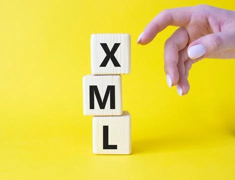 XML - Extensible Markup Language. Wooden cubes with word XML. Businessman h.. Stock Photos