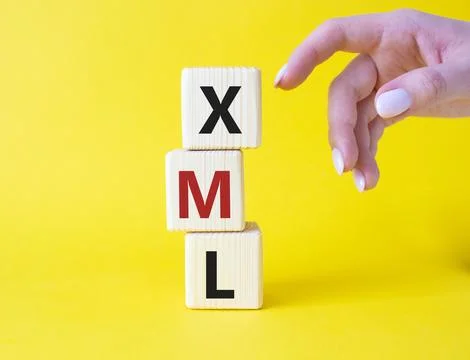 XML - Extensible Markup Language. Wooden cubes with word XML. Businessman han Stock Photos
