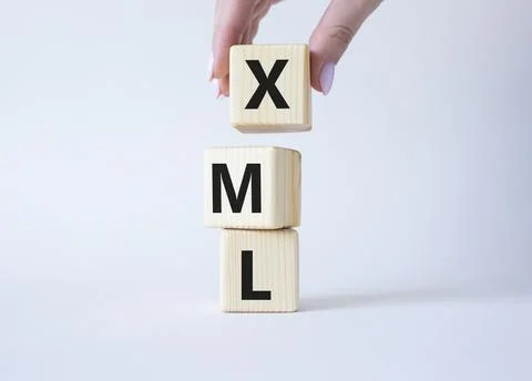 XML - Extensible Markup Language. Wooden cubes with word XML. Businessman h.. 写真素材