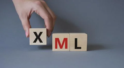 XML - Extensible Markup Language. Wooden cubes with word XML. Businessman h.. Foto stock