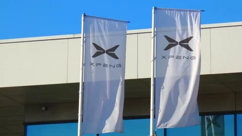 Xpeng building with flags seen in bright sunlight at a business location Stock Footage 337530709