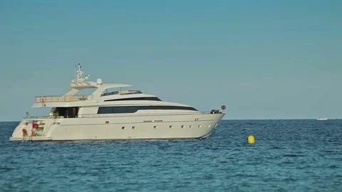The yacht is anchored next to the beach area. Spanish beaches in Cala Mendia Stock Footage 75612717