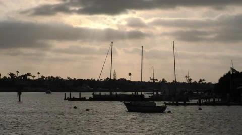 Yacht and docks in shadow while sun streaking through clouds during sun set.m Stock Footage 67466210