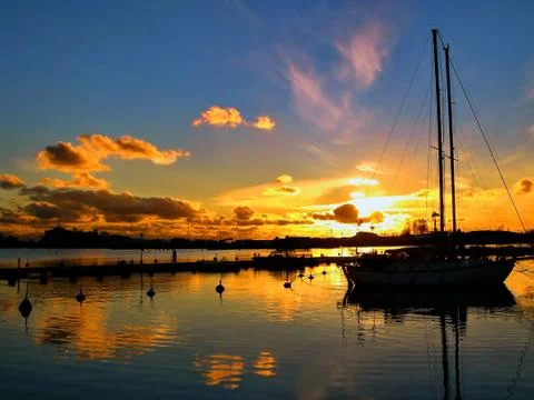 Yacht in the early evening. Sailboat On Sunset. Beautiful idyllic picture. Stock Photos