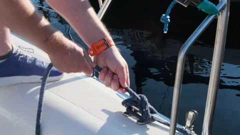 Yacht instructor demonstrates process of creating knot on cleat Stock Footage 262045726