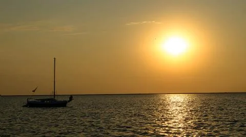 Yacht in the rays of the setting sun. 库存照片