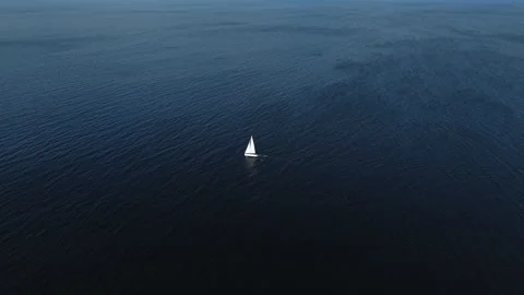 Yacht sailing empty vast ocean in dramatic Solitary perspective AERIAL Stock Footage 313341687