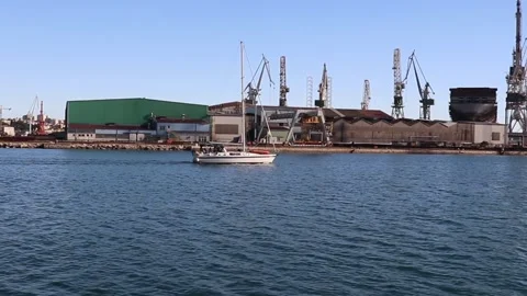 Yacht Is Sailing In Sea Clear Summer Day. Trade Port, Cranes Docks In Background Stock Footage 242589802