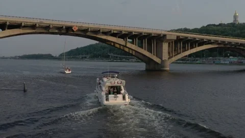 The yacht sails to the big bridge across the Dnieper river Stock Footage 195683403