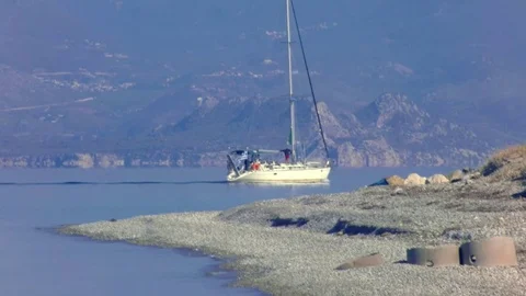 Yacht with sails down comes over the shore Stock Footage 83094391
