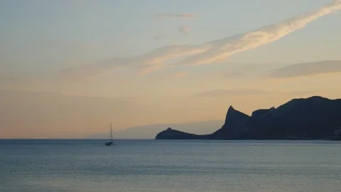 The yacht sails through the cape in the evening. Stock Footage 232868130