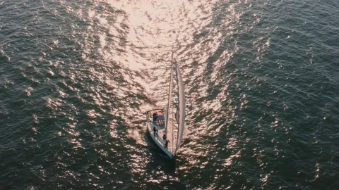 Yacht with white sails floating on the waves in the sun from sunset Stock Footage 198335400