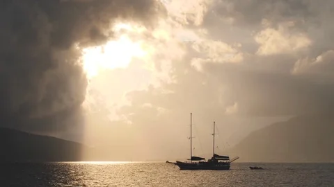 Yacht without sails and dramatic sky with sun beams from break in stormy clouds Stock Footage 83123461