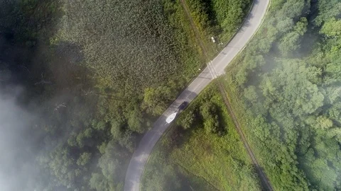 Yachting boat on trailer pulled by car on winding mountain road - drone aerial Stock Footage 99594877