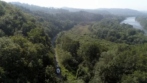 Yachting boat on trailer pulled by car on winding mountain road - drone aerial Stock Footage 99608874