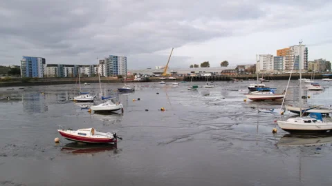 Yachts aground in mud during low tide in Granton Harbour in Edinburgh, UK - 4K Stock Footage 253821833
