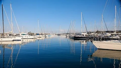 Yachts in the dock at sunset with reflection in the water. Mediterranean sea. 库存照片