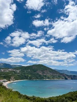 Yachts float in the bay surrounded by a high mountain range against a cloudy sky Fotos de archivo
