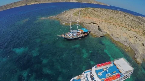 Yachts with tourists stand near a picturesque sea shore. Aerial view. Malta Stock Footage