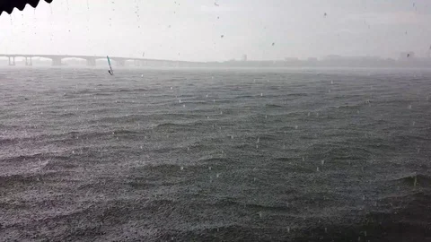 The yachtsman found himself in heavy rain on the river Stock Footage 125300041