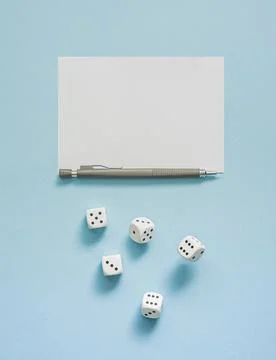 Yahtzee game in progress. Rolling dice, pencil and score sheet on a blue Stock Photos