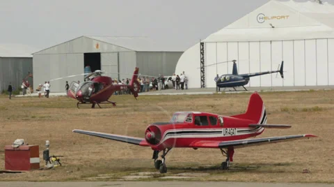 Yak-52 aircraft with the running engine parked with helicopter with working  Video stock 38572385